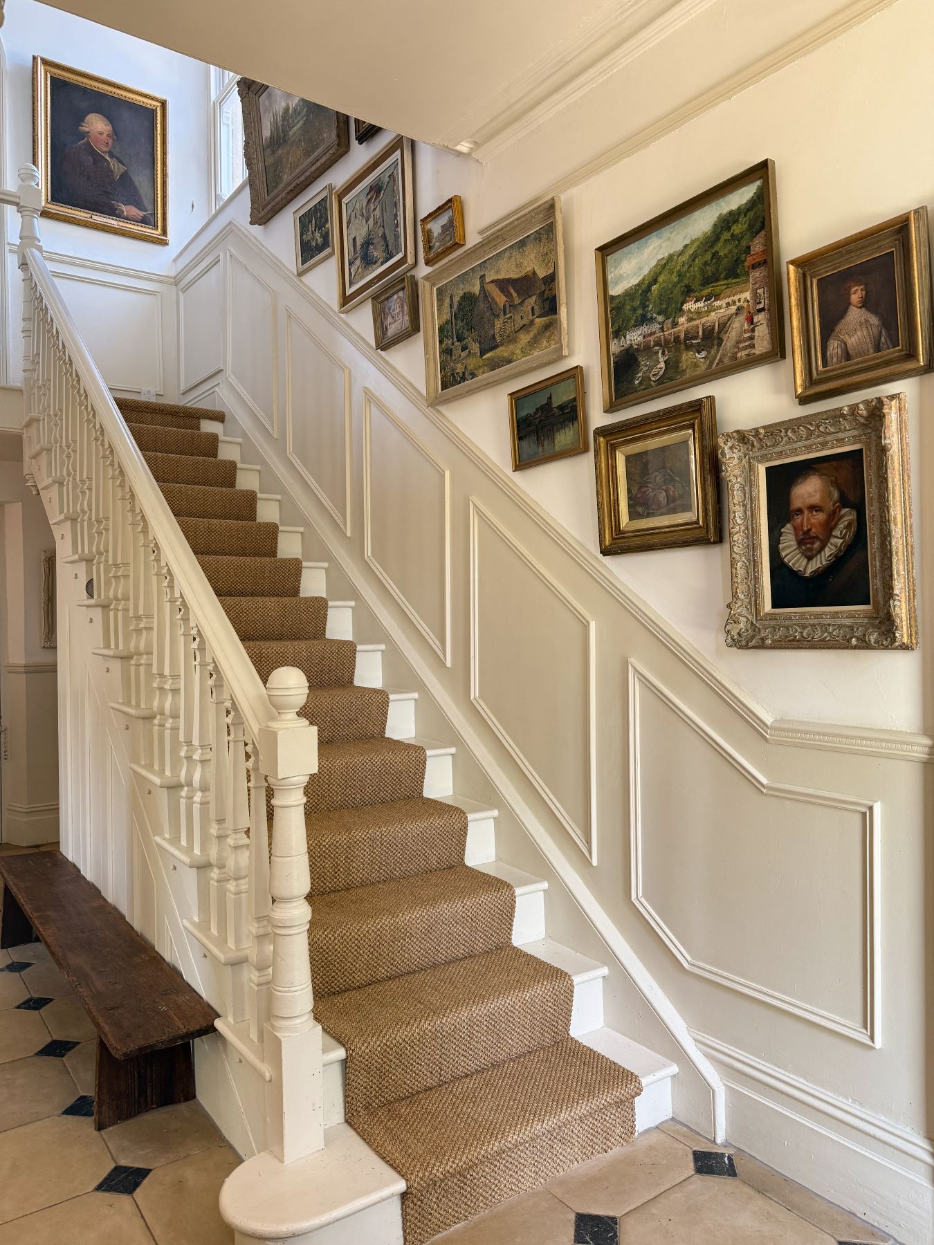 sisal stair runner carpet on cream wooden stairs in English country house
